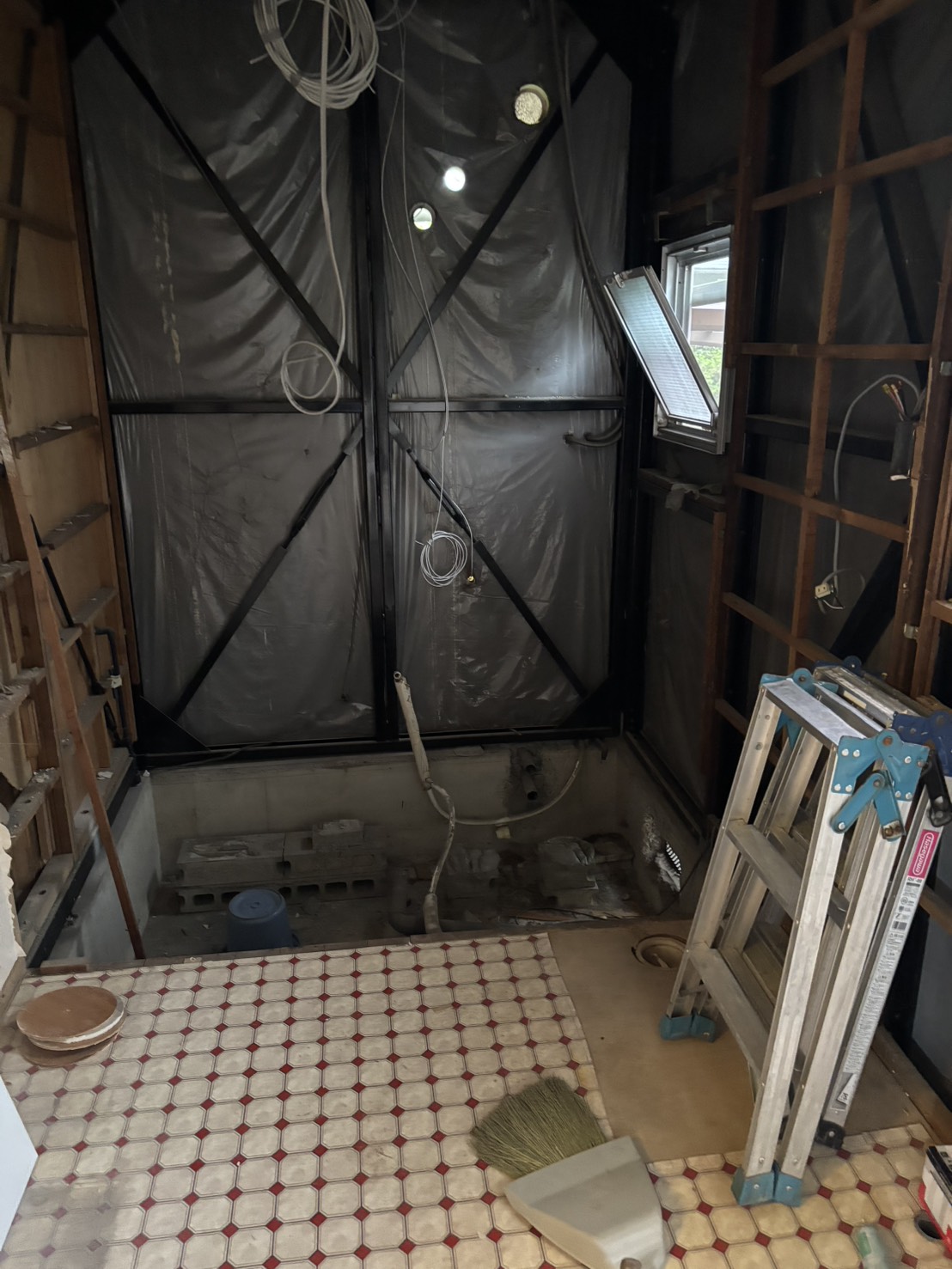 既存浴室設備を撤去して壁下地や配管を確認している解体中写真